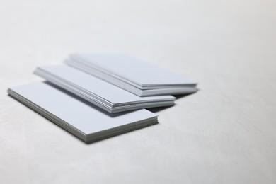 Photo of Blank business cards on light grey textured table, closeup. Mockup for design