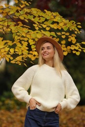 Photo of Portrait of happy woman wearing warm sweater in autumn park