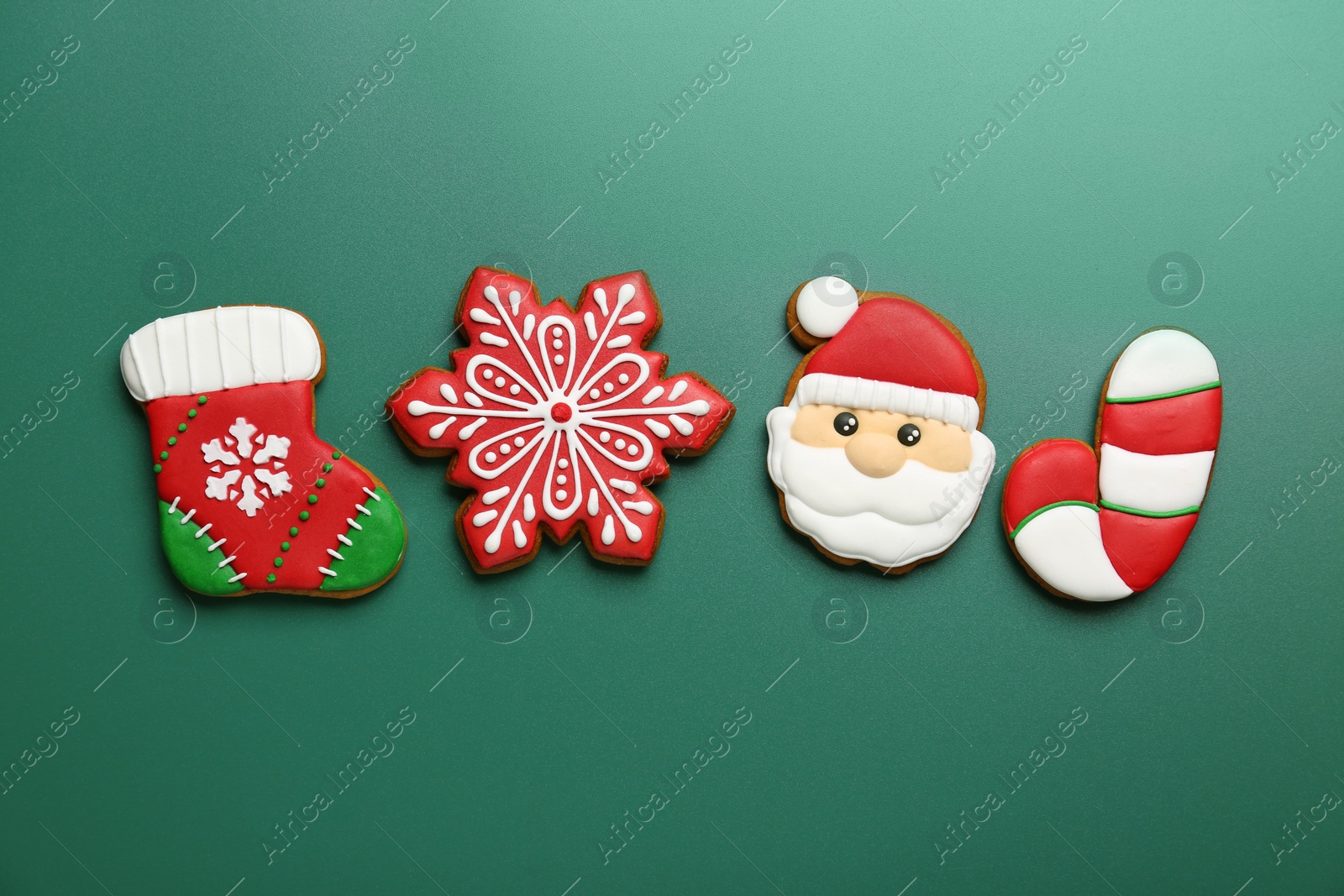 Photo of Different tasty Christmas cookies on green background, flat lay