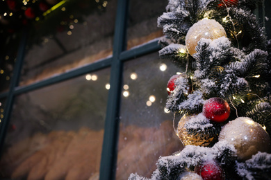 Beautiful decorative garland near window outdoors. Christmas celebration