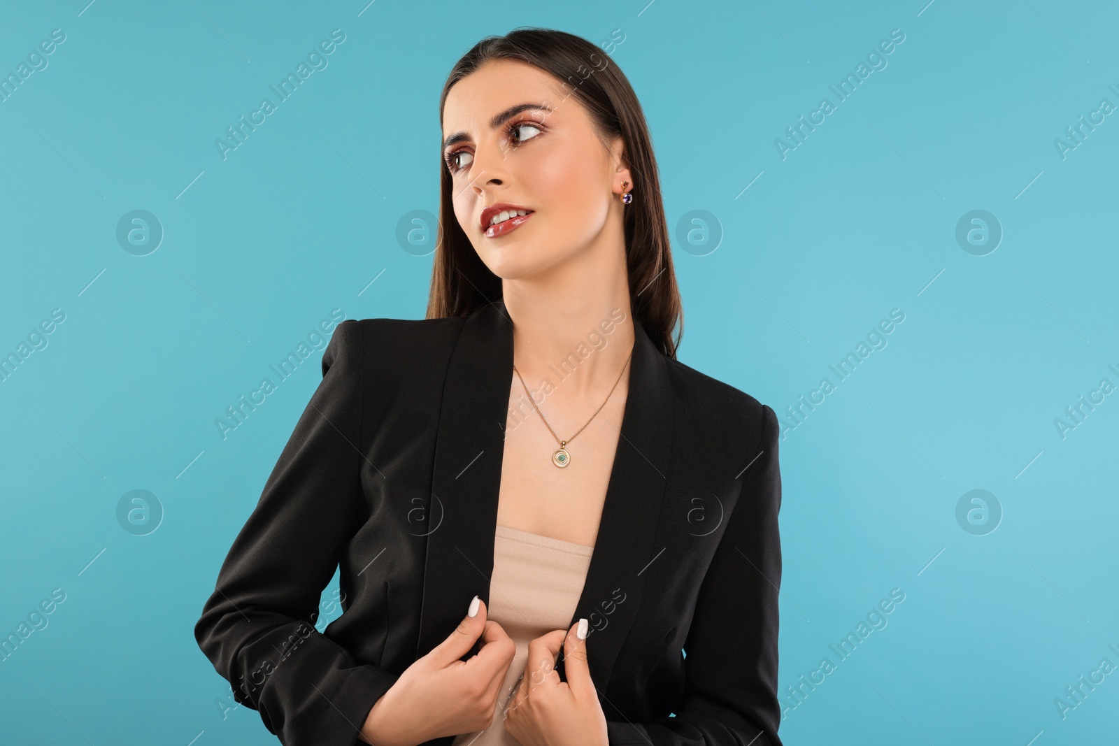 Photo of Beautiful woman with elegant jewelry on light blue background