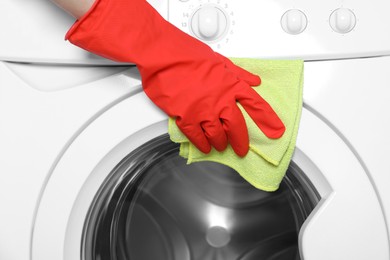 Photo of Woman cleaning washing machine with rag, closeup