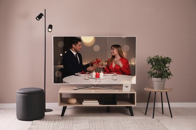 Image of Scene of romantic movie on TV in room