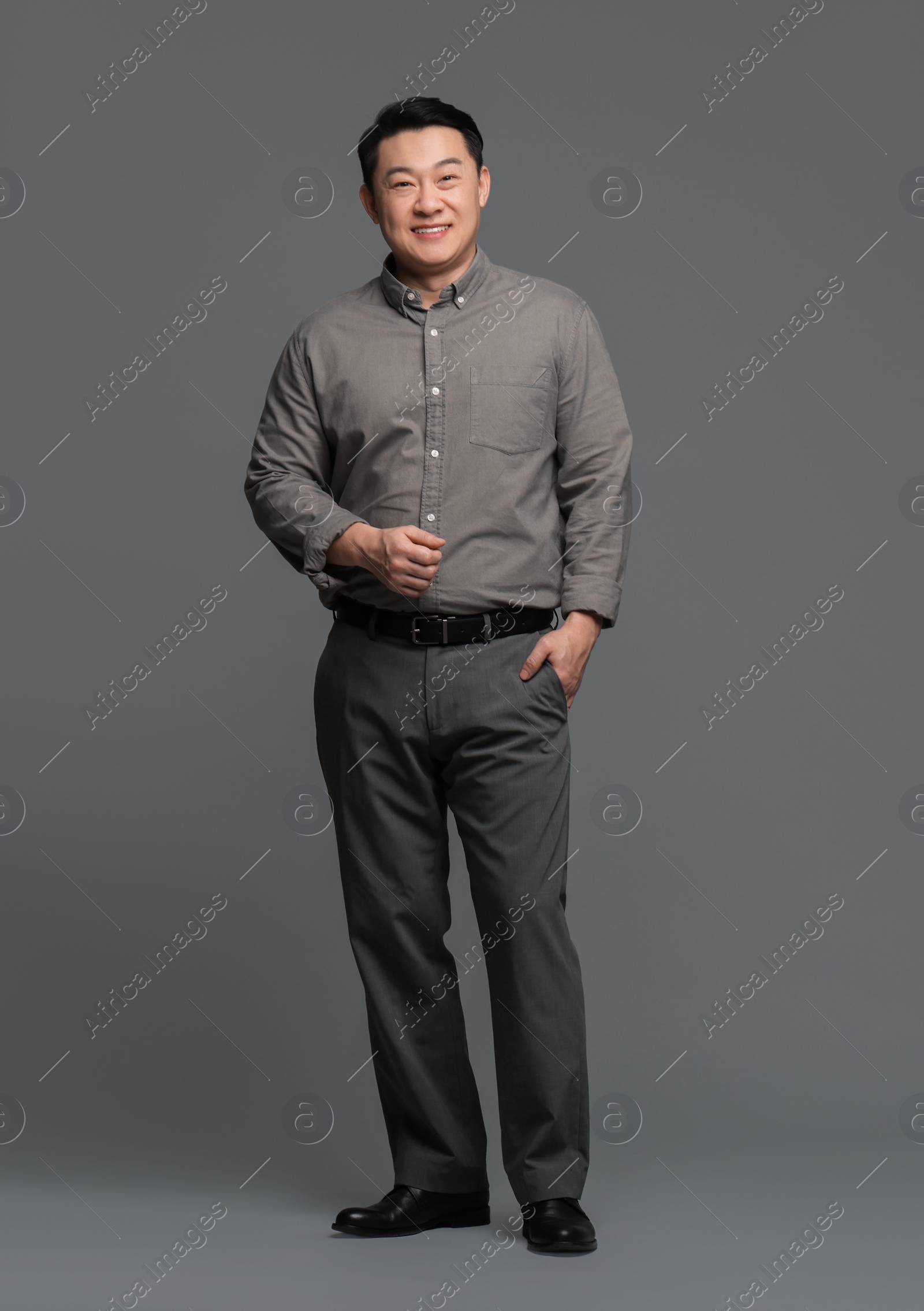 Photo of Full length portrait of happy businessman on grey background. Space for text