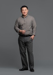 Full length portrait of happy businessman on grey background. Space for text