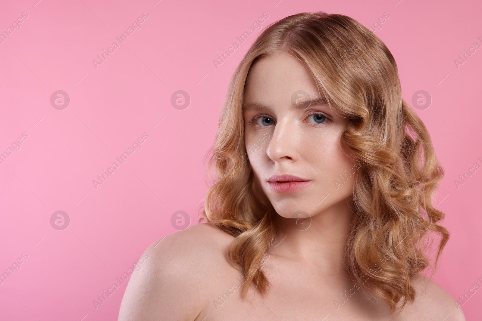 Photo of Portrait of beautiful woman with blonde hair on pink background. Space for text