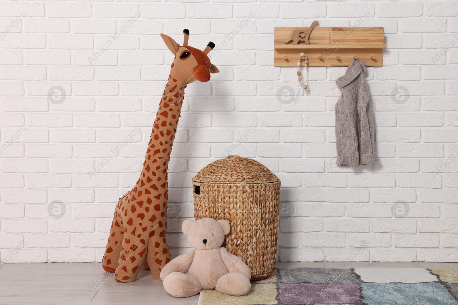 Photo of Beautiful children's room with white brick wall and toys. Interior design