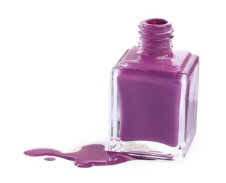 Photo of Bottle and spilled purple nail polish isolated on white