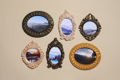 Photo of Vintage frames with photos of beautiful landscapes hanging on beige wall