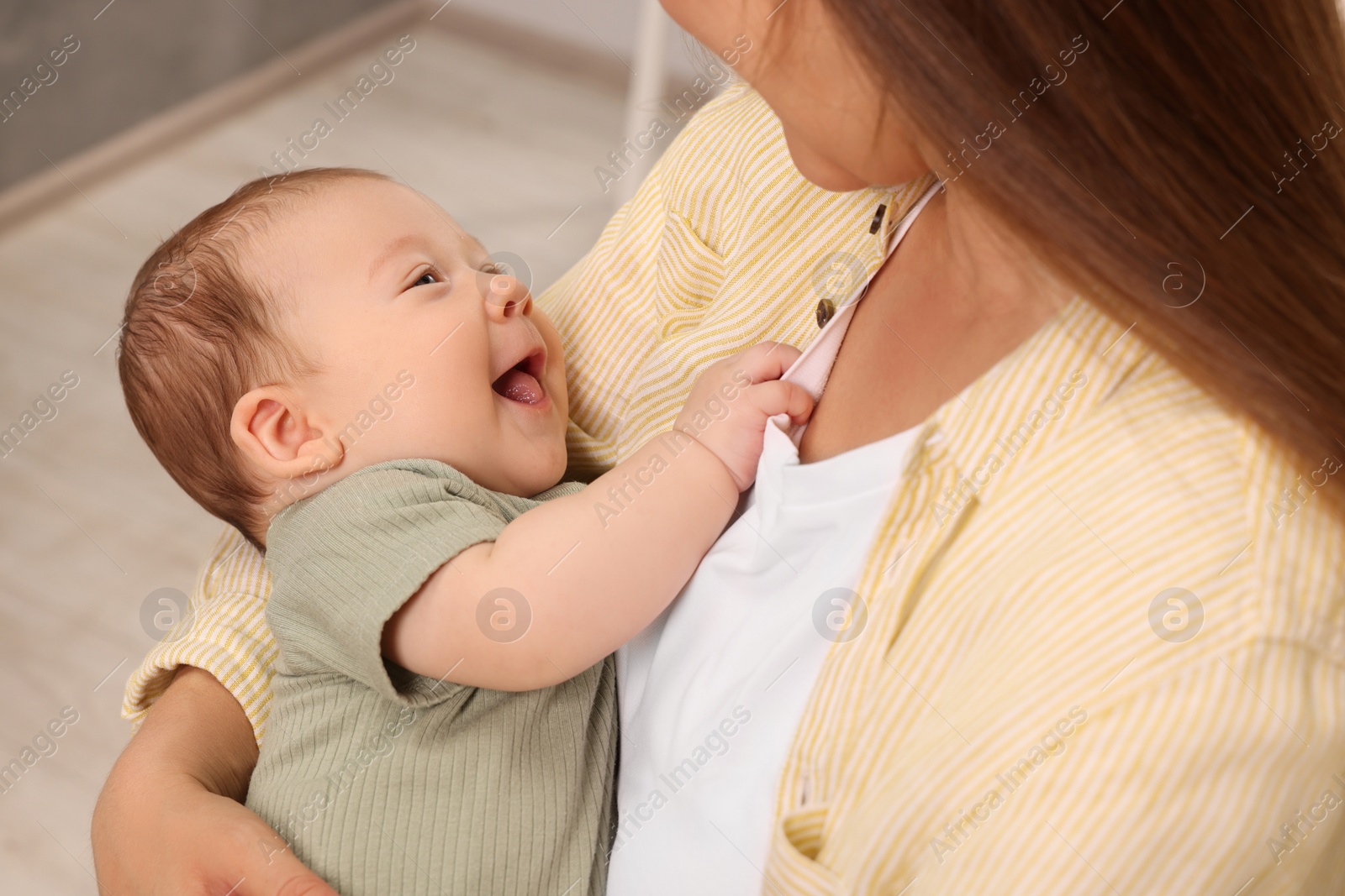 Photo of Mother holding her cute newborn baby at home, closeup