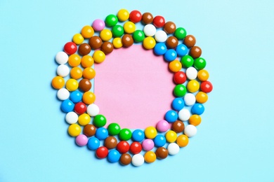 Photo of Frame made of delicious candies on color background, top view. Space for text
