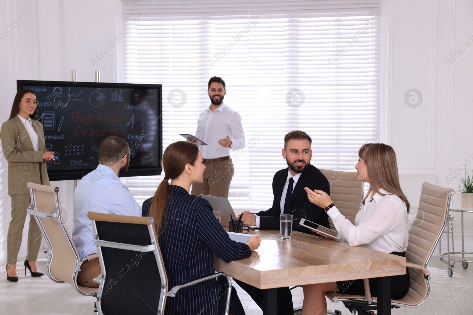 Photo of Business training. People in meeting room with interactive board