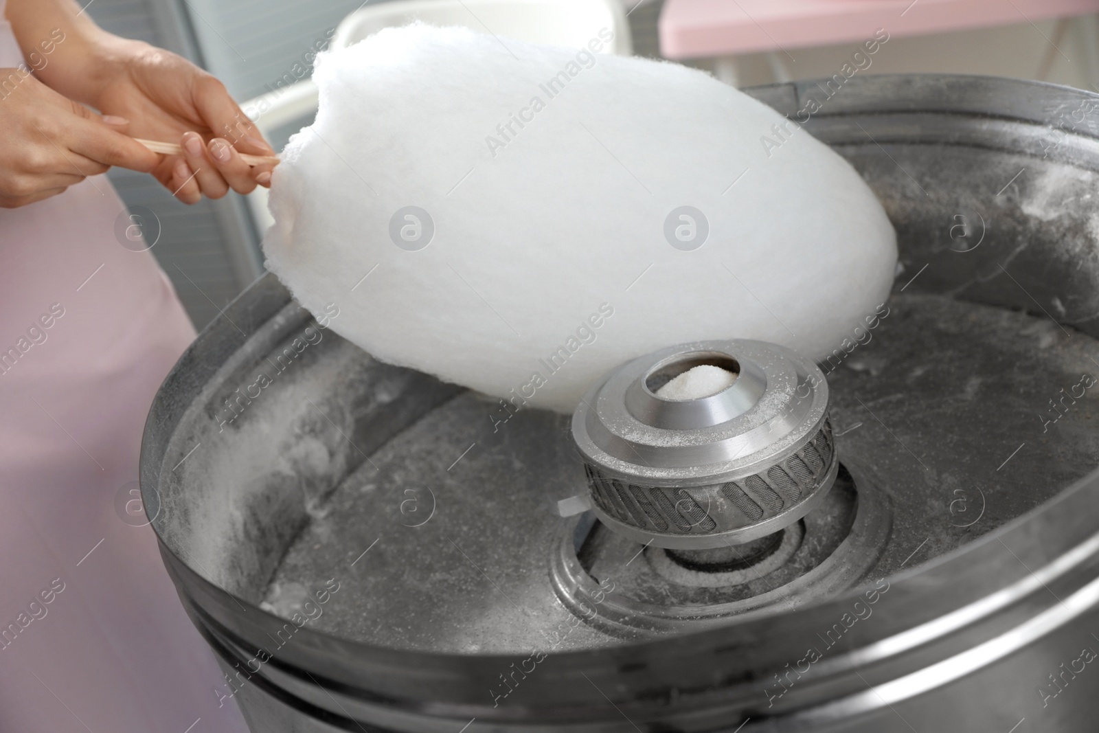 Photo of Woman making cotton candy using modern machine indoors, closeup