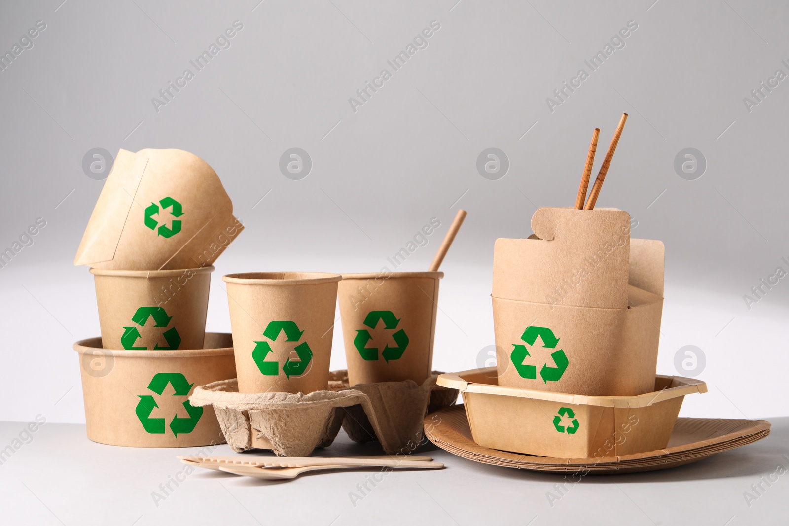 Image of Set of eco friendly food packaging with recycling symbols on light background