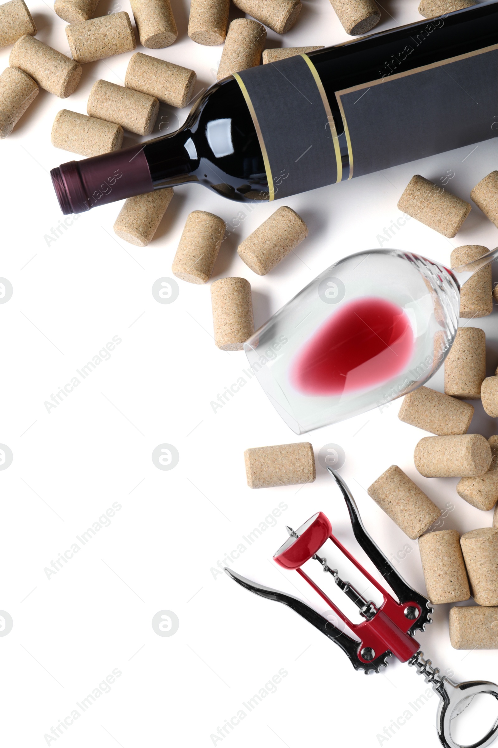 Photo of Corkscrew with wine bottle, glass and stoppers on white background, top view