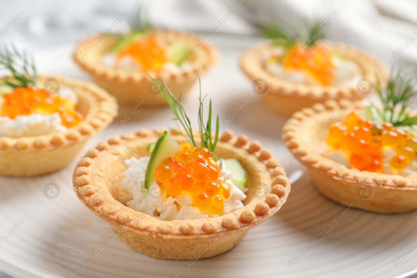 Photo of Delicious canapes with red caviar on plate, closeup