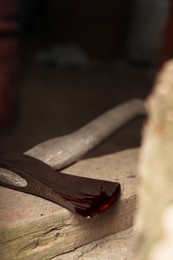Photo of Axe with blood on wooden threshold, closeup