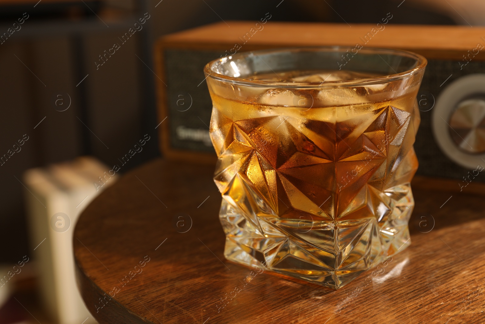 Photo of Glass of whiskey on wooden table indoors, closeup. Relax at home