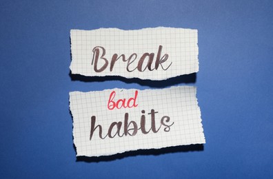 Photo of Torn paper with phrase Break Bad Habits on blue background, flat lay