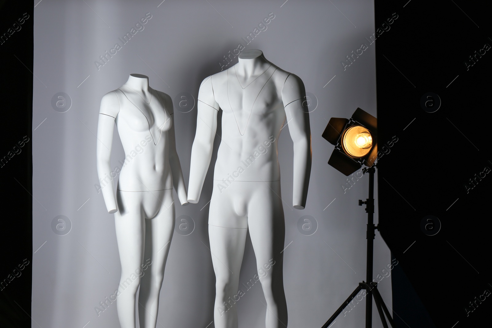 Photo of Ghost mannequins and professional lighting equipment in modern photo studio