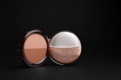 Photo of Open face powder with puff applicator on black background, closeup