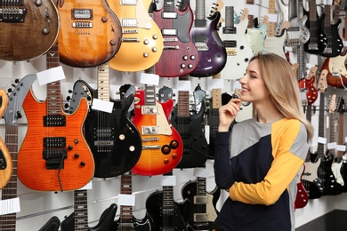 Buyer choosing guitar in modern music store