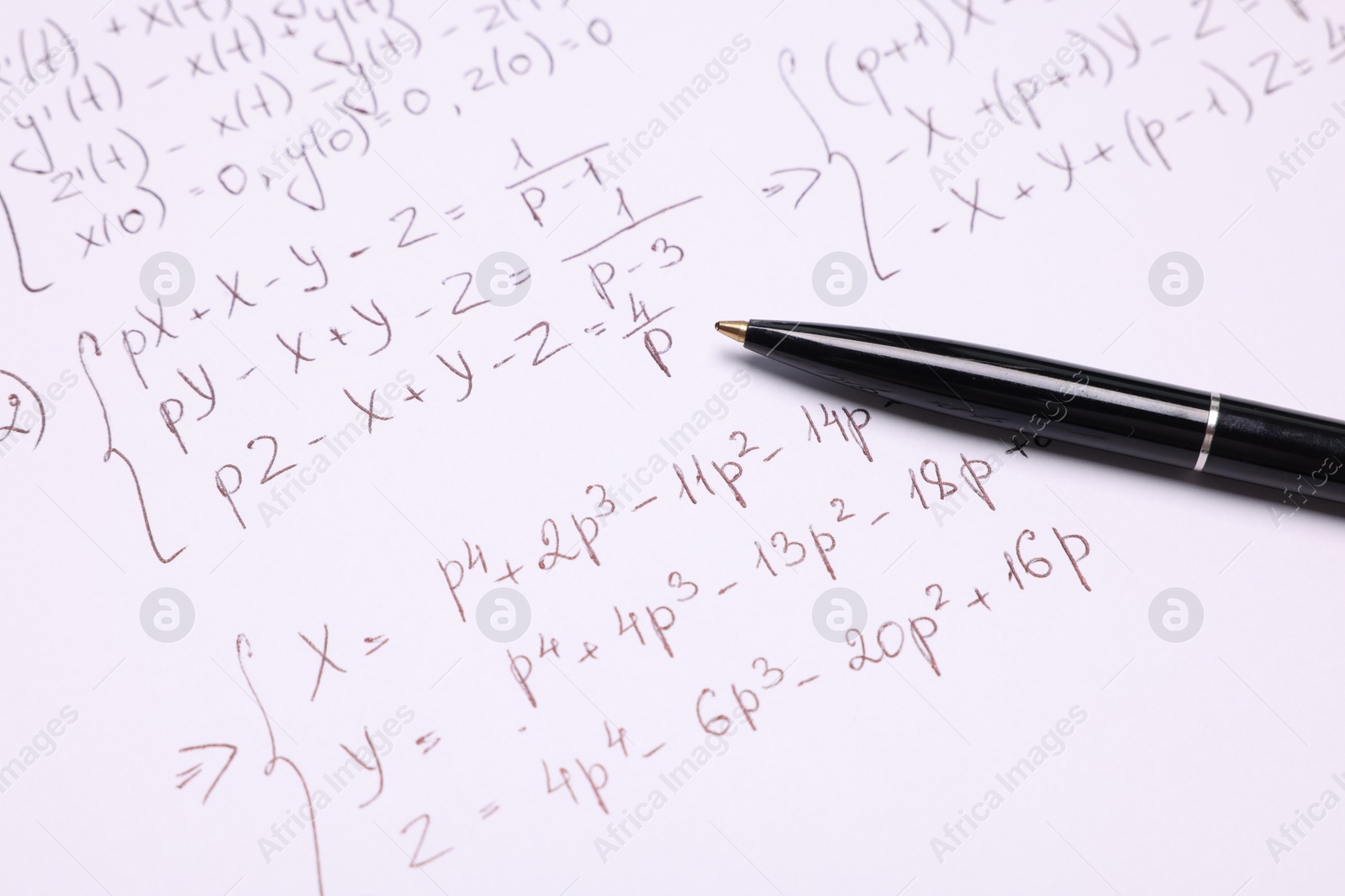 Photo of Sheet of paper with mathematical formulas and pen, closeup