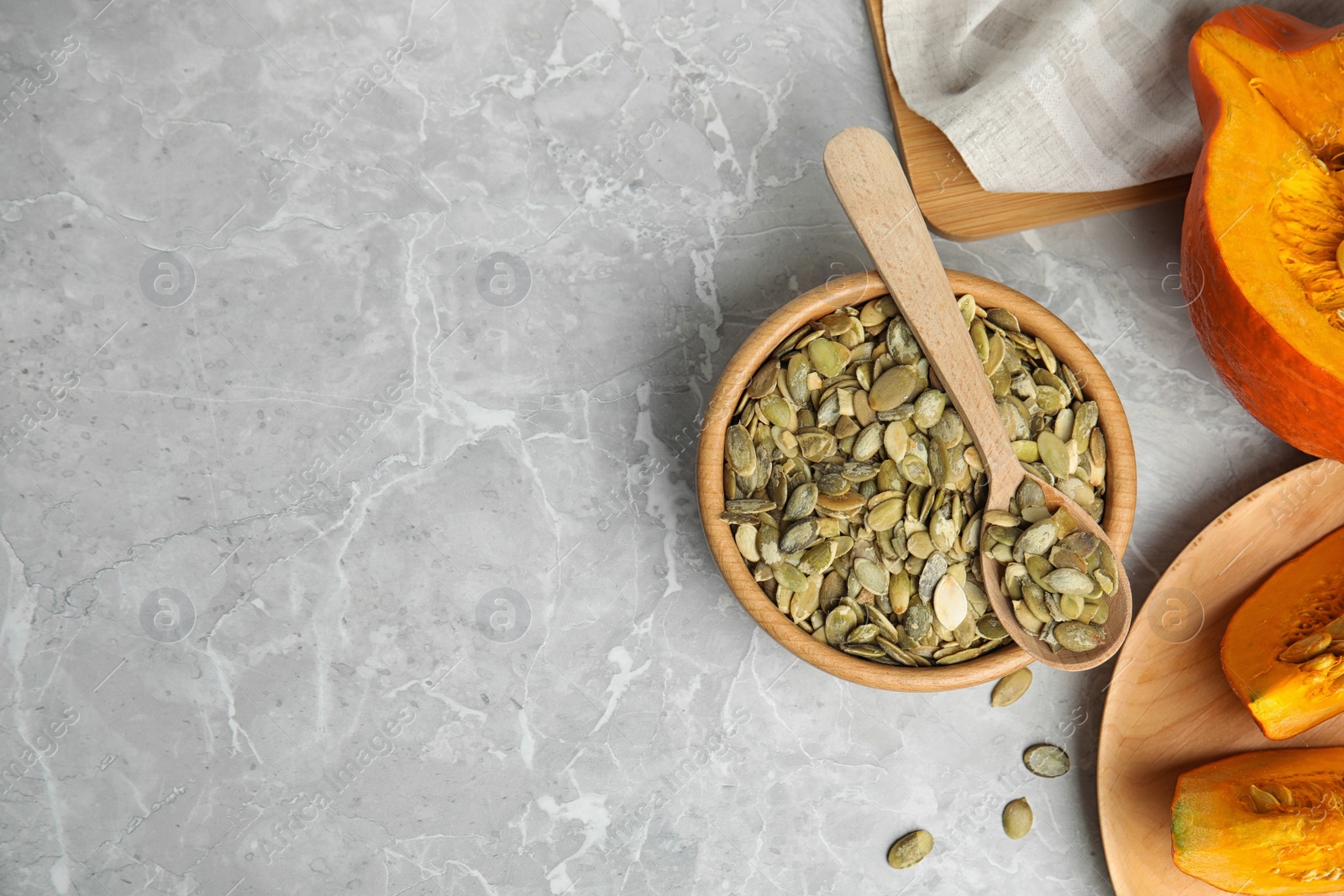 Photo of Flat lay composition with raw pumpkin seeds on light grey marble table. Space for text