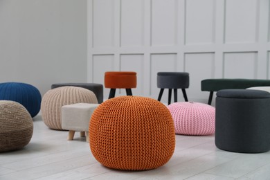 Different stylish poufs and ottomans in room