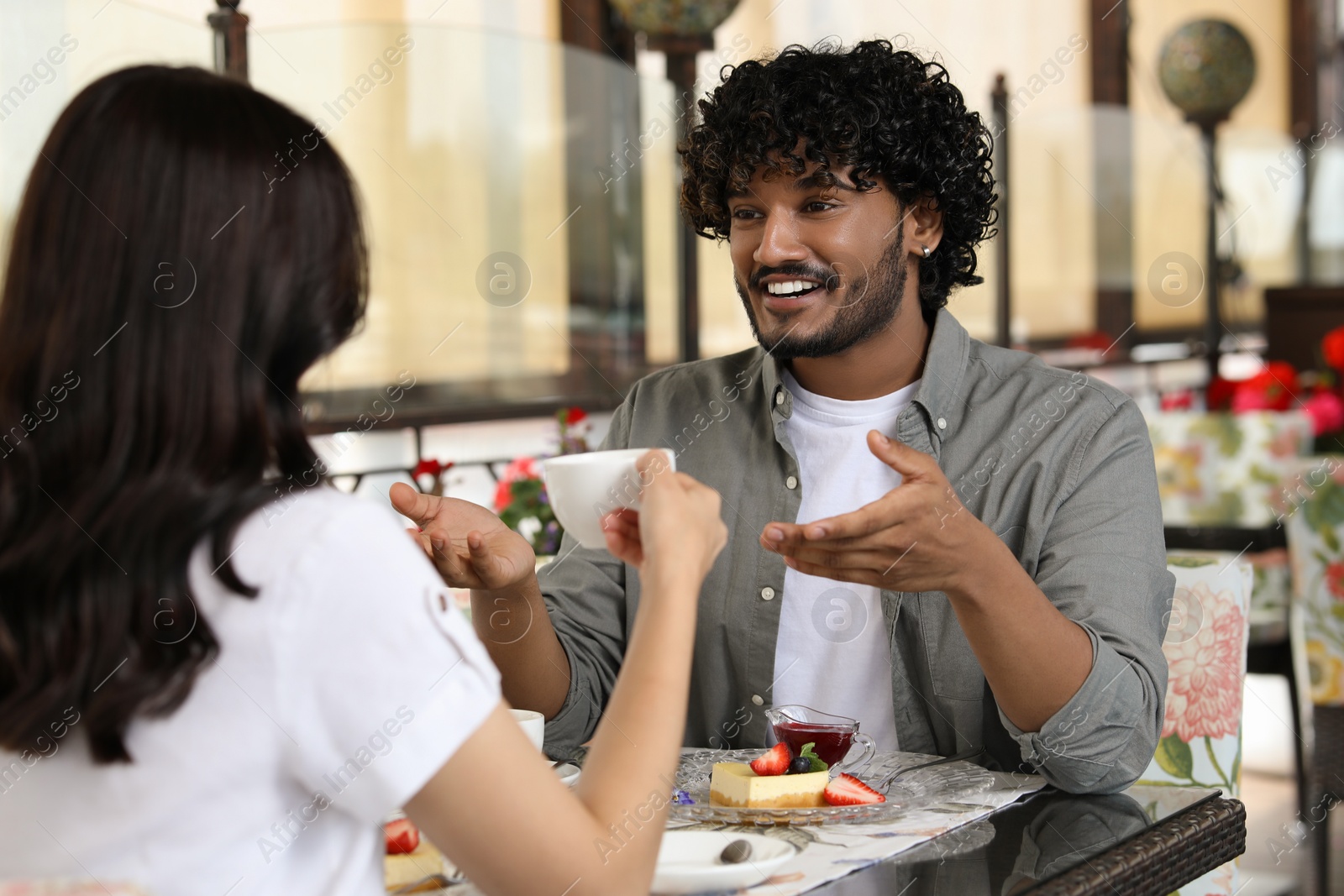 Photo of International dating. Happy couple spending time together in restaurant