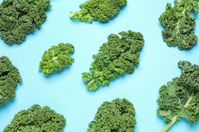 Photo of Fresh kale leaves on light blue background, flat lay