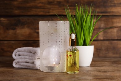 Photo of Composition with aroma lamp and essential oil on wooden table