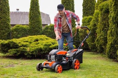 Man with modern lawn mower in garden