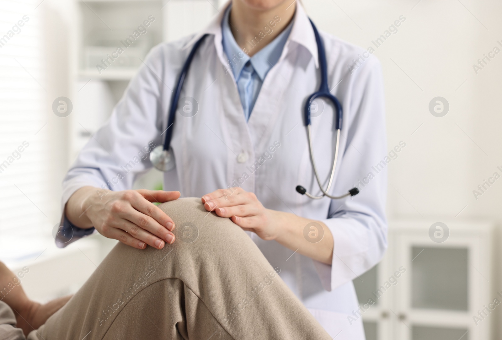 Photo of Arthritis symptoms. Doctor examining patient with knee pain in hospital, closeup