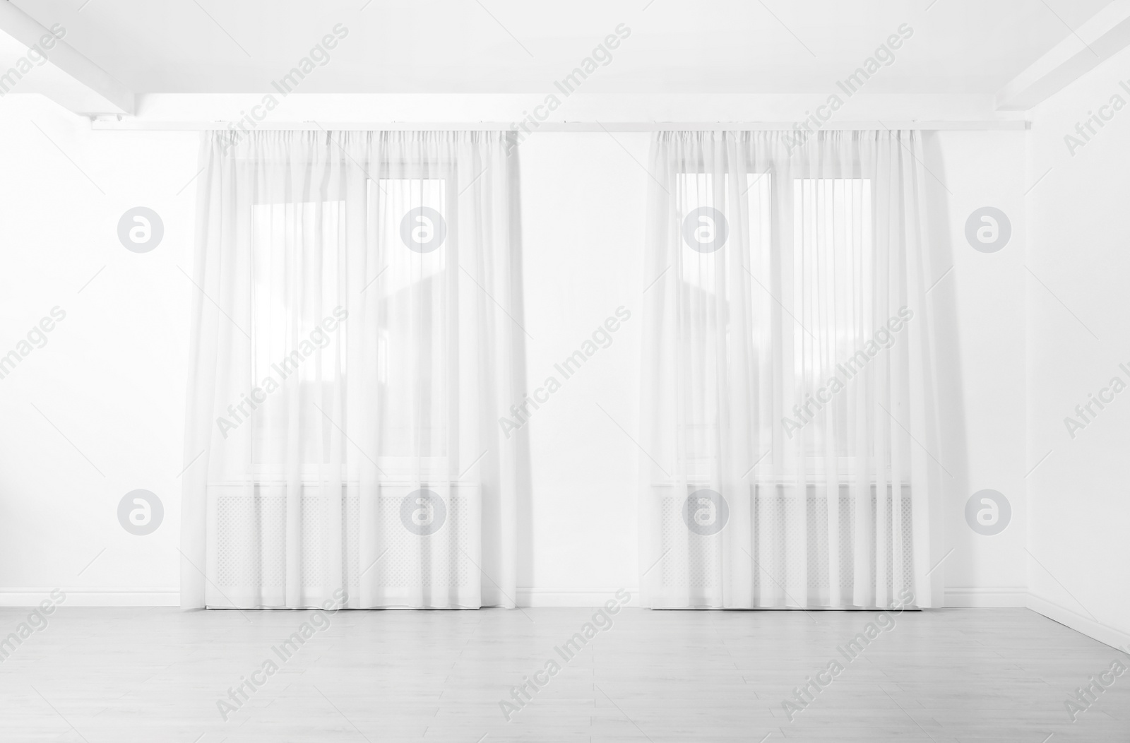 Photo of Windows with elegant curtains in empty room