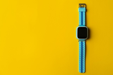 Kid smart watch on yellow background, top view. Space for text