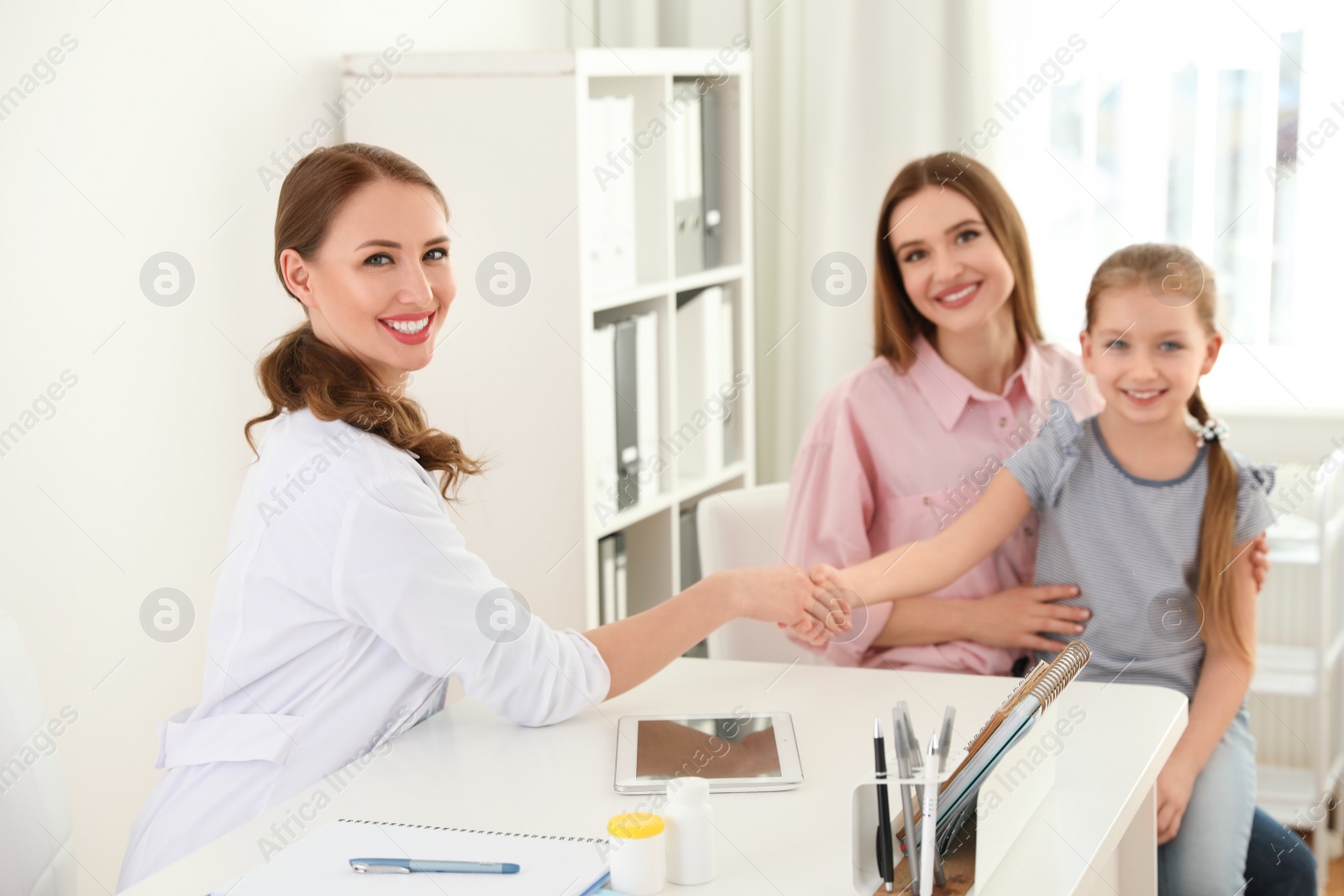 Photo of Mother and daughter visiting pediatrician. Doctor working with patient in hospital