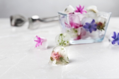 Photo of Composition with floral ice cubes on table, space for text