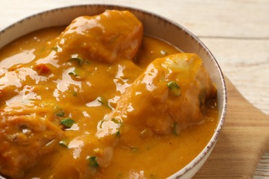 Photo of Tasty chicken curry on wooden table, closeup. Space for text