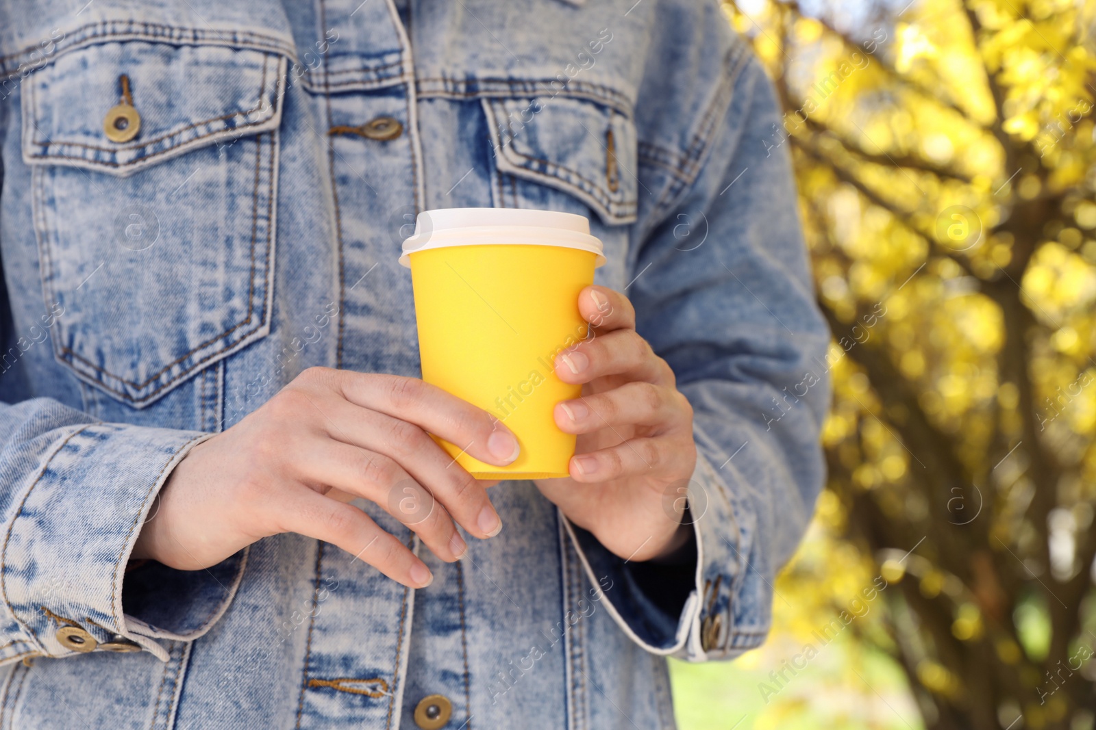 Photo of Woman with paper cup of coffee outdoors on sunny day, closeup