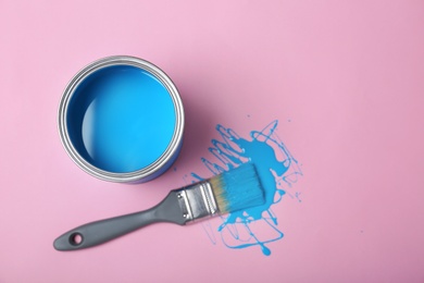 Photo of Flat lay composition with paint can and dipped brush on color background. Space for text