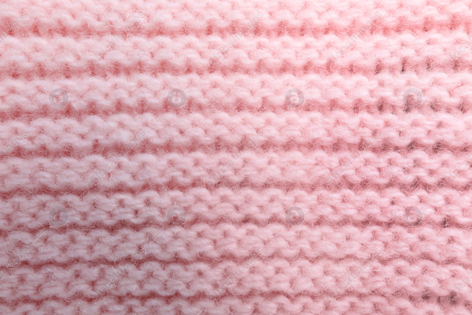 Photo of Pink knitted sweater as background, closeup view