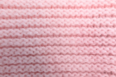 Photo of Pink knitted sweater as background, closeup view