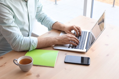 Young man working with laptop at desk. Home office