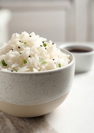 Photo of Bowl of tasty cooked rice served on table, closeup