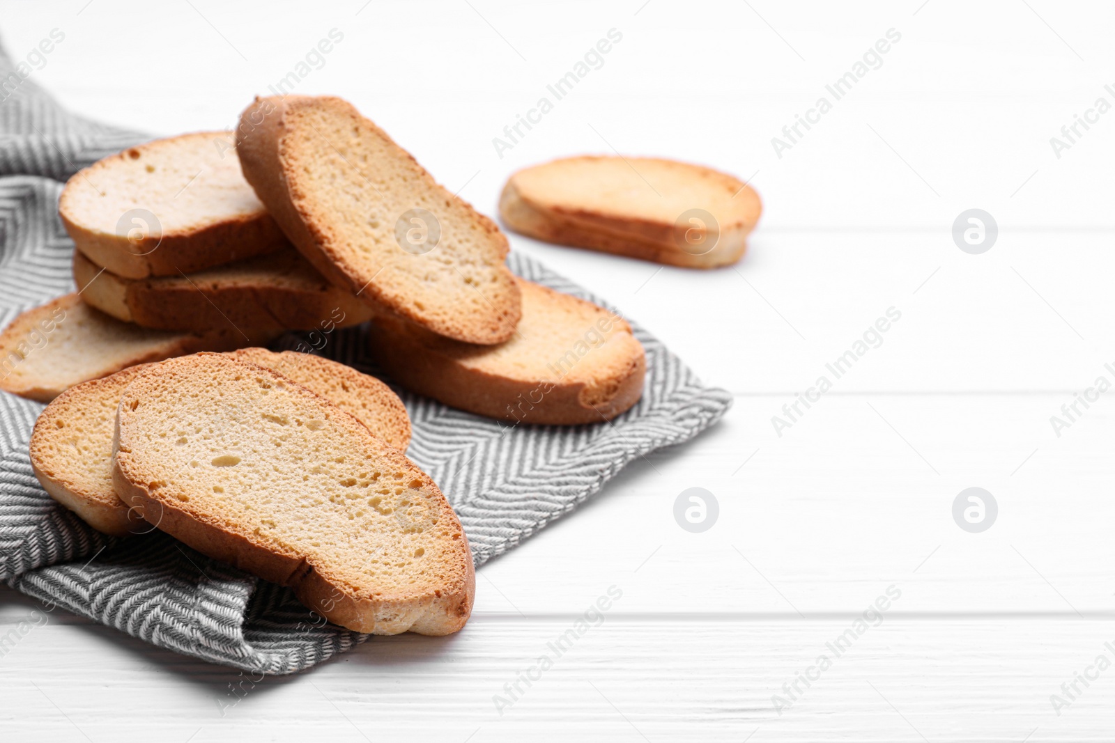 Photo of Tasty hard chuck crackers on white wooden table. Space for text