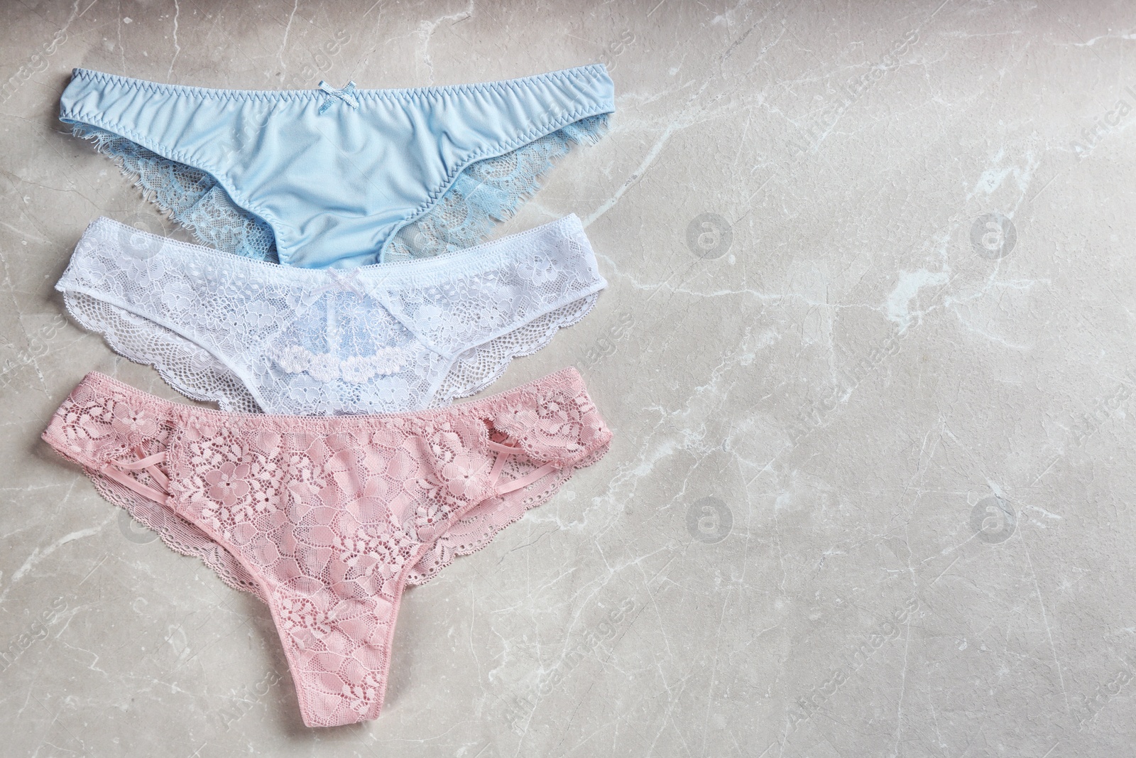 Photo of Sexy women's underwear on light grey background, flat lay. Space for text