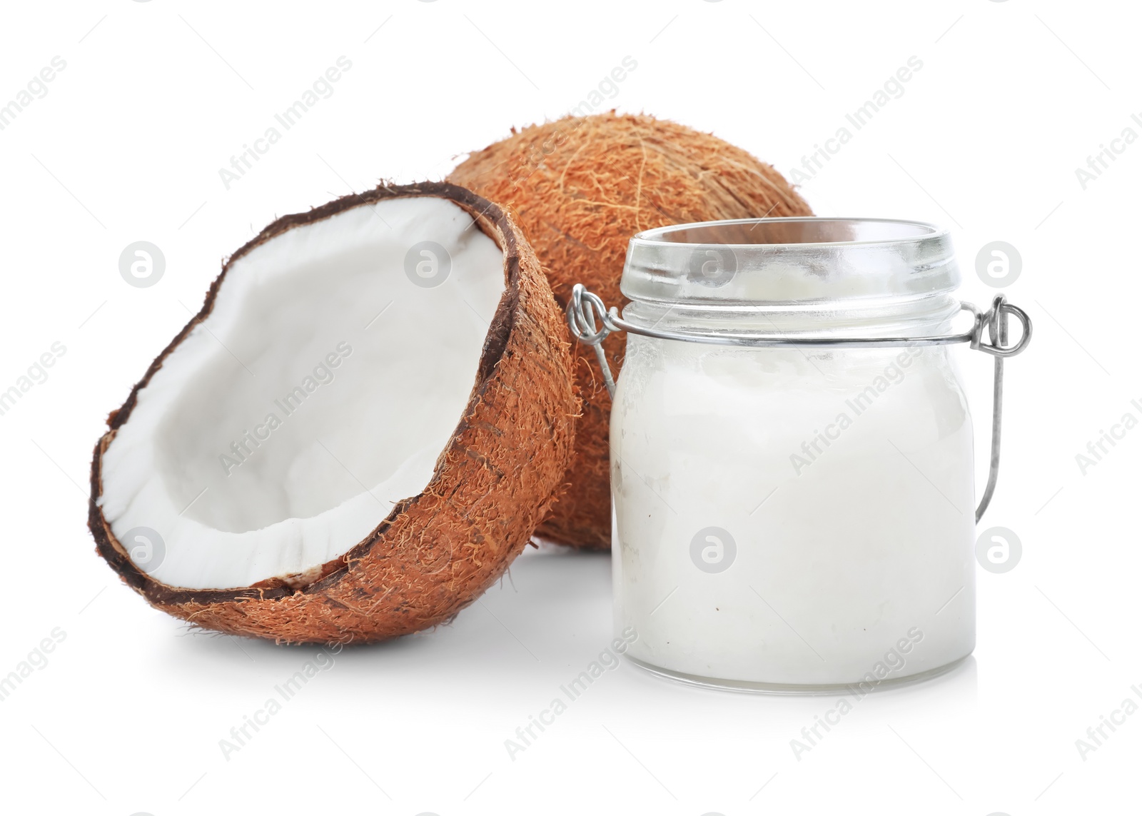 Photo of Ripe coconut and jar with oil on white background. Healthy cooking