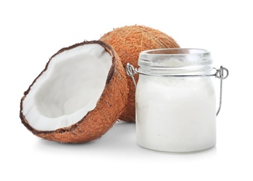 Photo of Ripe coconut and jar with oil on white background. Healthy cooking