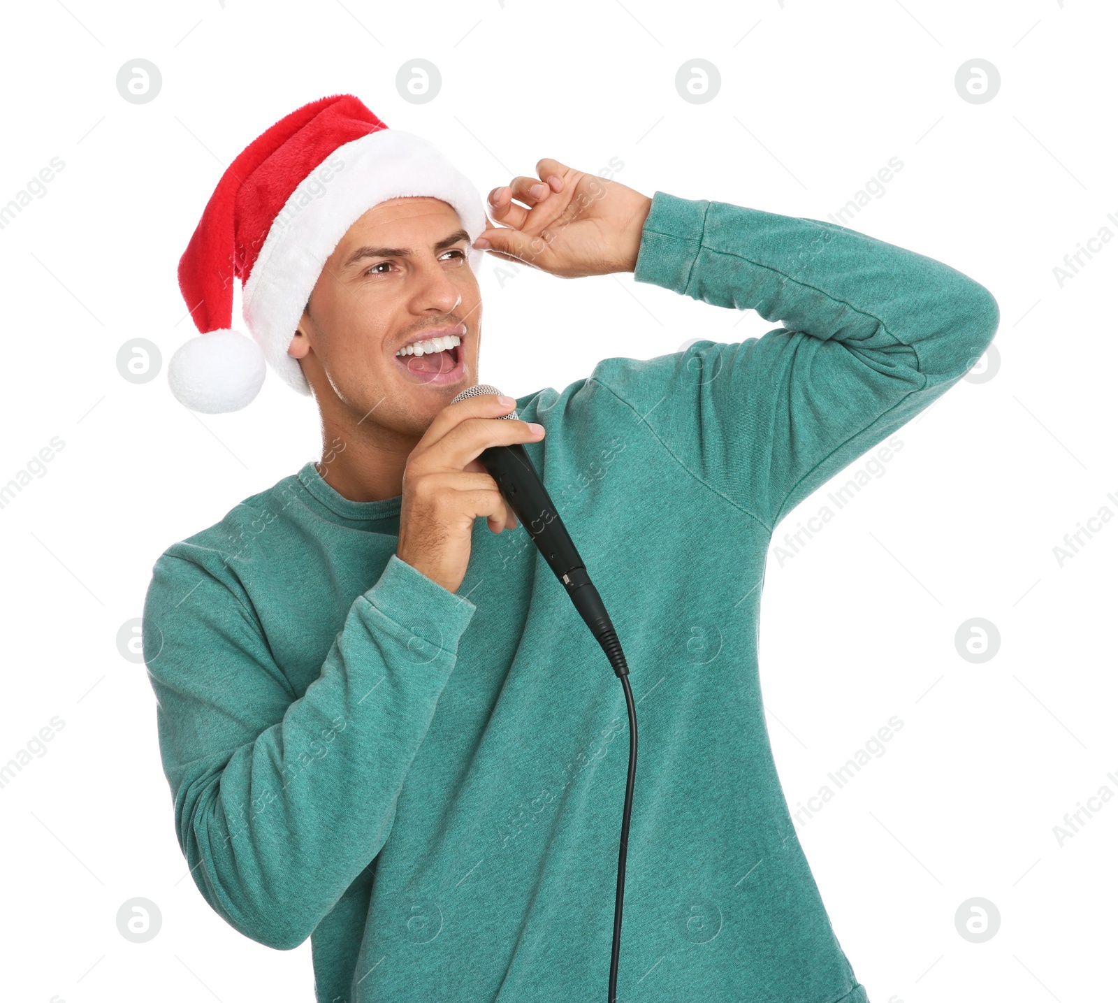 Photo of Emotional man in Santa Claus hat singing with microphone on white background. Christmas music